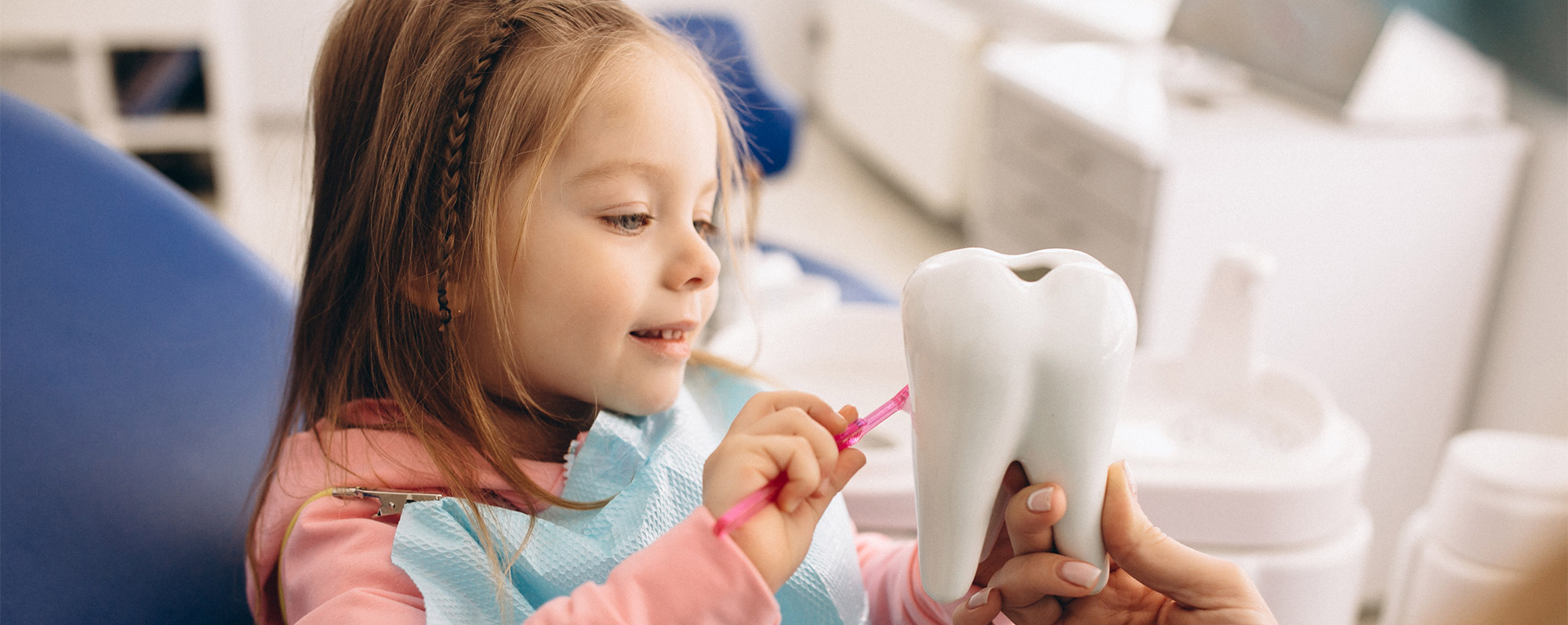 Little girl brushing fake tooth